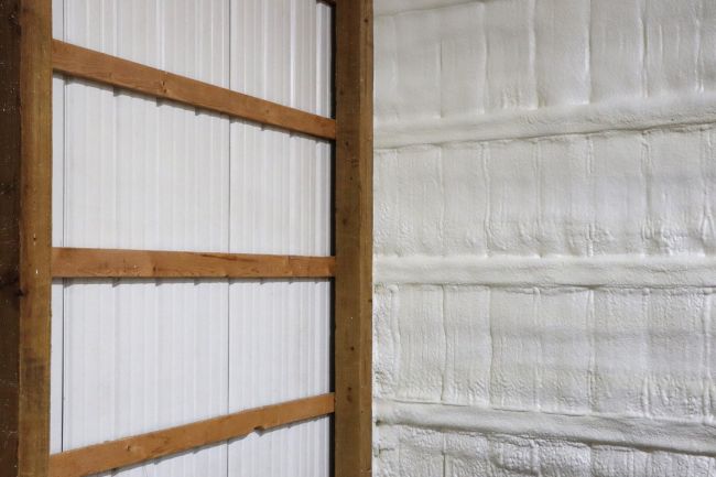 Aplicación de espuma de poliuretano proyectada en paramento vertical para aislamiento térmico y sellado.