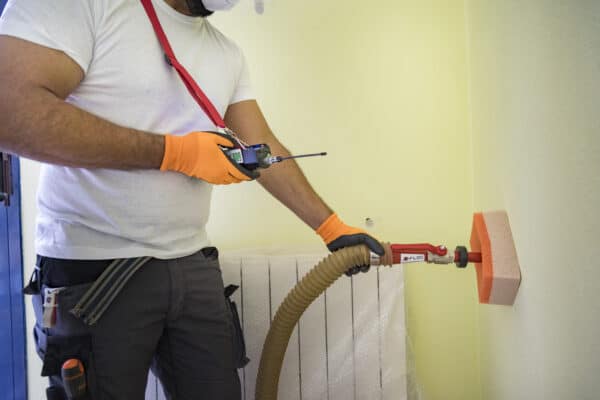 Instalador insuflando camara de aire Instalador profesional insuflando aislamiento térmico en la cámara de aire de una vivienda.