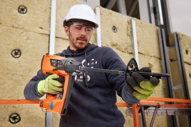 insulfast 2 Instalador utilizando una clavadora SPIT PULSA INSULFAST para fijar paneles de aislamiento en una estructura de obra.