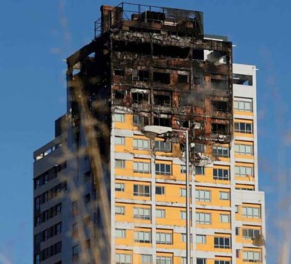 Fachada de edificio de gran altura con graves daños tras un incendio, que evidencia la propagación del fuego por el revestimiento exterior.