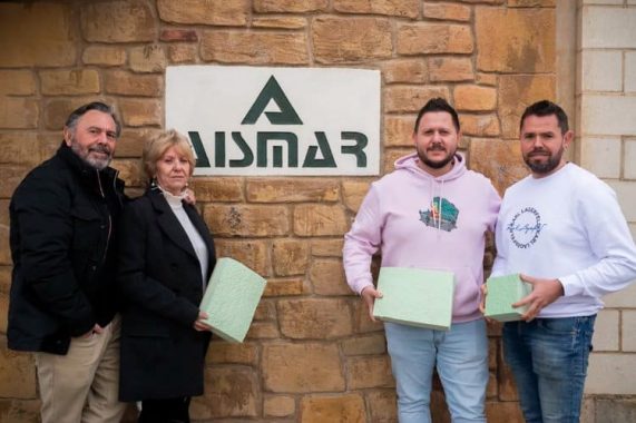 Equipo de Grupo Aismar frente a su sede en Ribaforada con motivo del 40º aniversario, sosteniendo muestras de aislamiento.