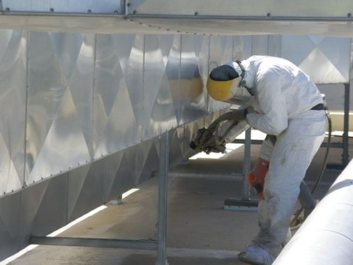 Operario preparando una superficie metálica con amoladora antes de aplicar un sistema de impermeabilización o recubrimiento.